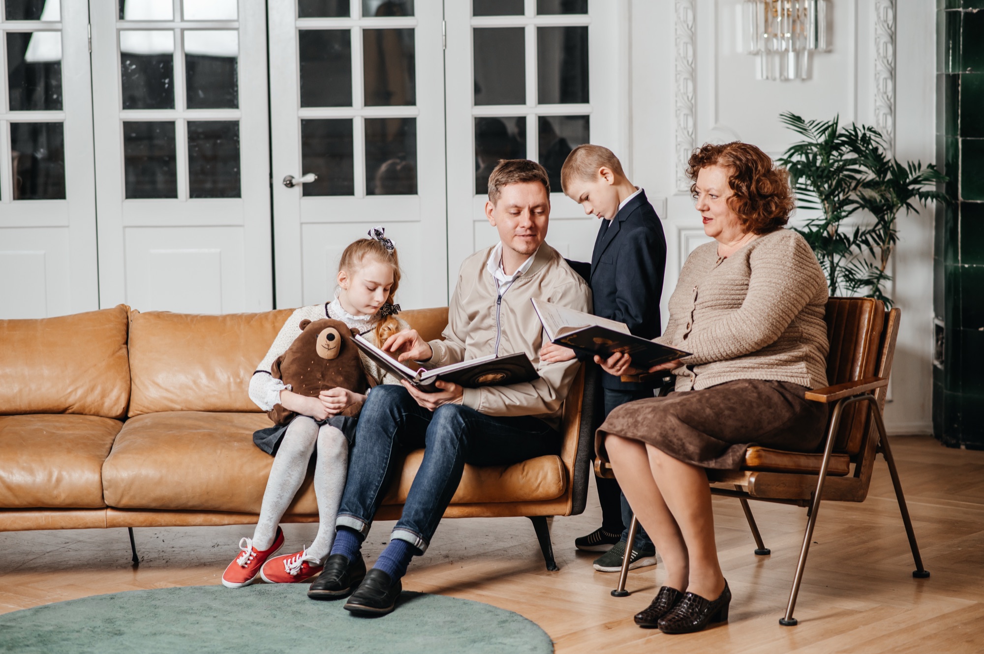 Павел с мамой и детьми читают родословную книгу